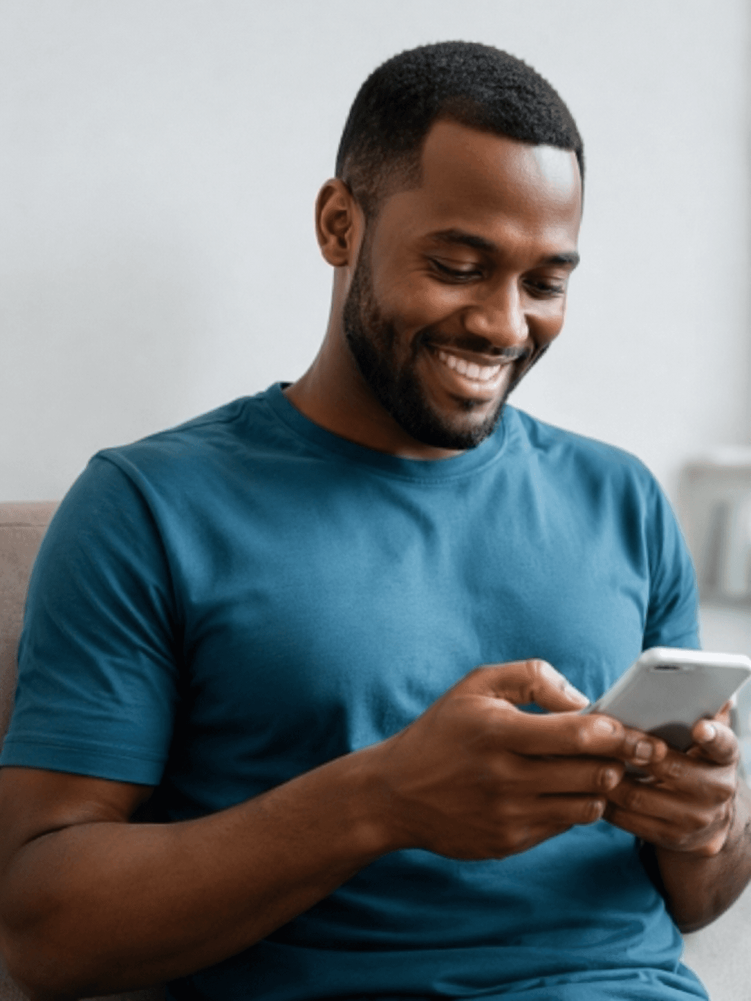 Man smiling while using his phone.